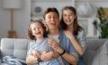 Smiling father with his two daughters on a couch. Happy family moments in Frazer, a scene of love and togetherness. West Chester, PA