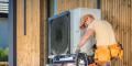 HVAC technician servicing an outdoor air conditioning unit, surrounded by tools, illustrating maintenance and repair for air conditioning issues.