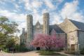 Historic stone building with towers and a blooming cherry tree in West Chester, PA, under a partly cloudy sky. Spring is in the air!