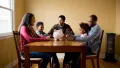 Family gathered around a dining table with a piggy bank, discussing financial savings and budgeting in a cozy home setting.