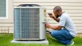 Man performing maintenance on an outdoor air conditioning unit, inspecting components and ensuring optimal performance for home cooling systems.