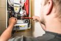 Technician repairing heating system, demonstrating emergency heating service expertise for Precision Air Heating in West Chester, PA.