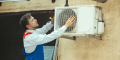 HVAC technician servicing an outdoor air conditioning unit, emphasizing reliability and expertise in heating and cooling solutions for homes in Paoli, PA.
