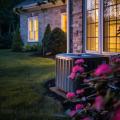 Modern air conditioning unit in West Chester home, surrounded by flowers and grass, highlighting HVAC maintenance and efficiency.