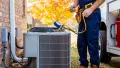 HVAC technician servicing an air conditioning unit outside a home in West Chester, PA, ensuring efficient cooling and heating solutions.