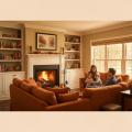 Cozy family gathering in a warm living room with a fireplace, featuring a couple and two children sitting together on an orange sectional sofa, surrounded by bookshelves and autumn decor.