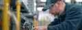 Technician performing maintenance on HVAC equipment, emphasizing air conditioning system efficiency and tune-up services by Precision Air, Heating and Cooling.
