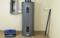 Heat pump water heater installation. Gray water heater with toolbox nearby, electrical panel, and other tools. Switch to heat pump water heater.