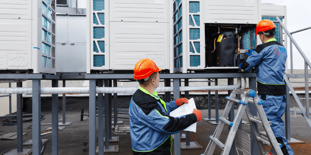 HVAC system replacement: Technicians inspect rooftop units. Considering HVAC system replacement in West Chester, PA? Call today!