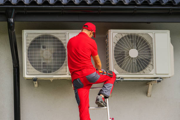 HVAC technician installing heat pump on West Chester home.