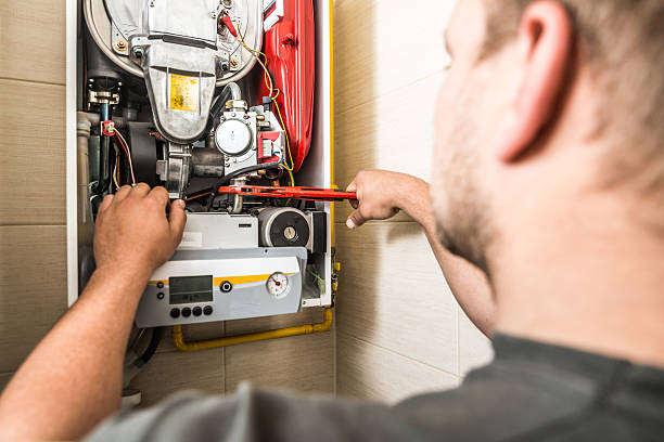 Technician repairing heating system, demonstrating emergency heating service expertise for Precision Air Heating in West Chester, PA.