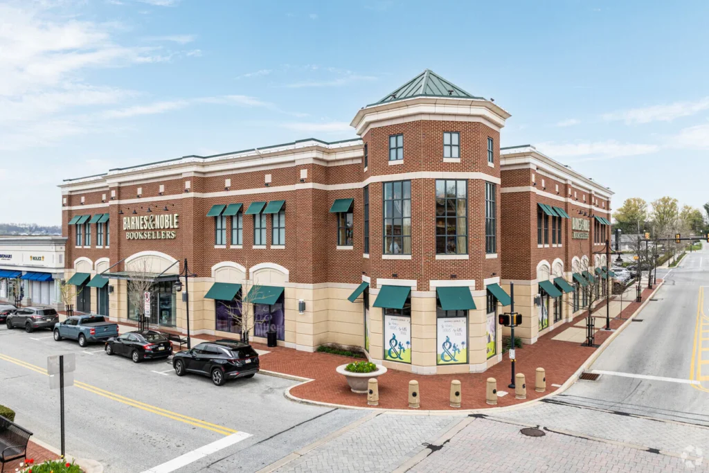 Barnes & Noble Booksellers storefront on Main Street at Exton, featuring a brick facade, green awnings, and surrounding parked cars, highlighting the vibrant shopping atmosphere in Exton, PA.