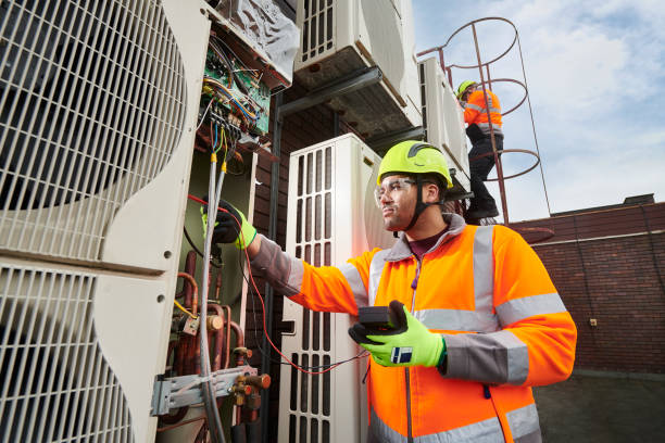 HVAC technician in safety gear inspecting air conditioning unit, highlighting professional maintenance services for home comfort in Exton.