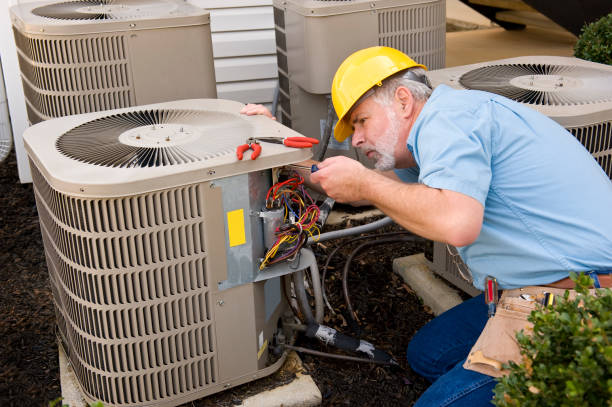 Heating Contractor in West Chester, PA, expertly repairs an air conditioning unit, ensuring optimal performance and customer satisfaction.