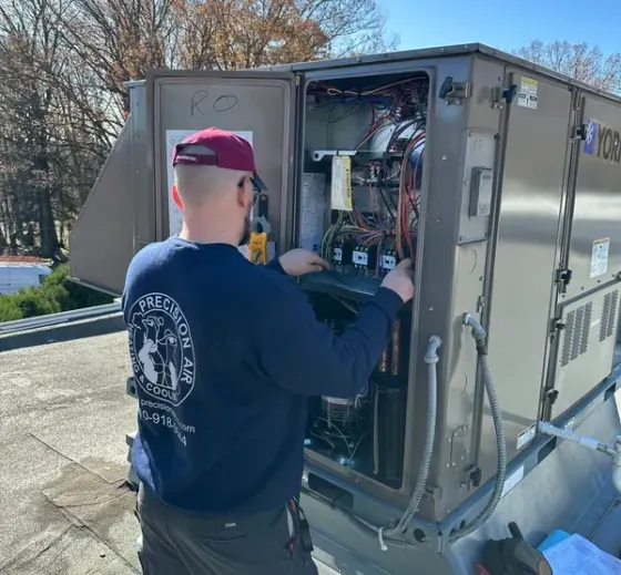 Precision Air technician testing electrical components in a York rooftop unit