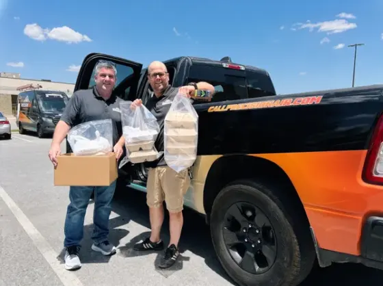 Precision Air team members loading food donations beside the company truck