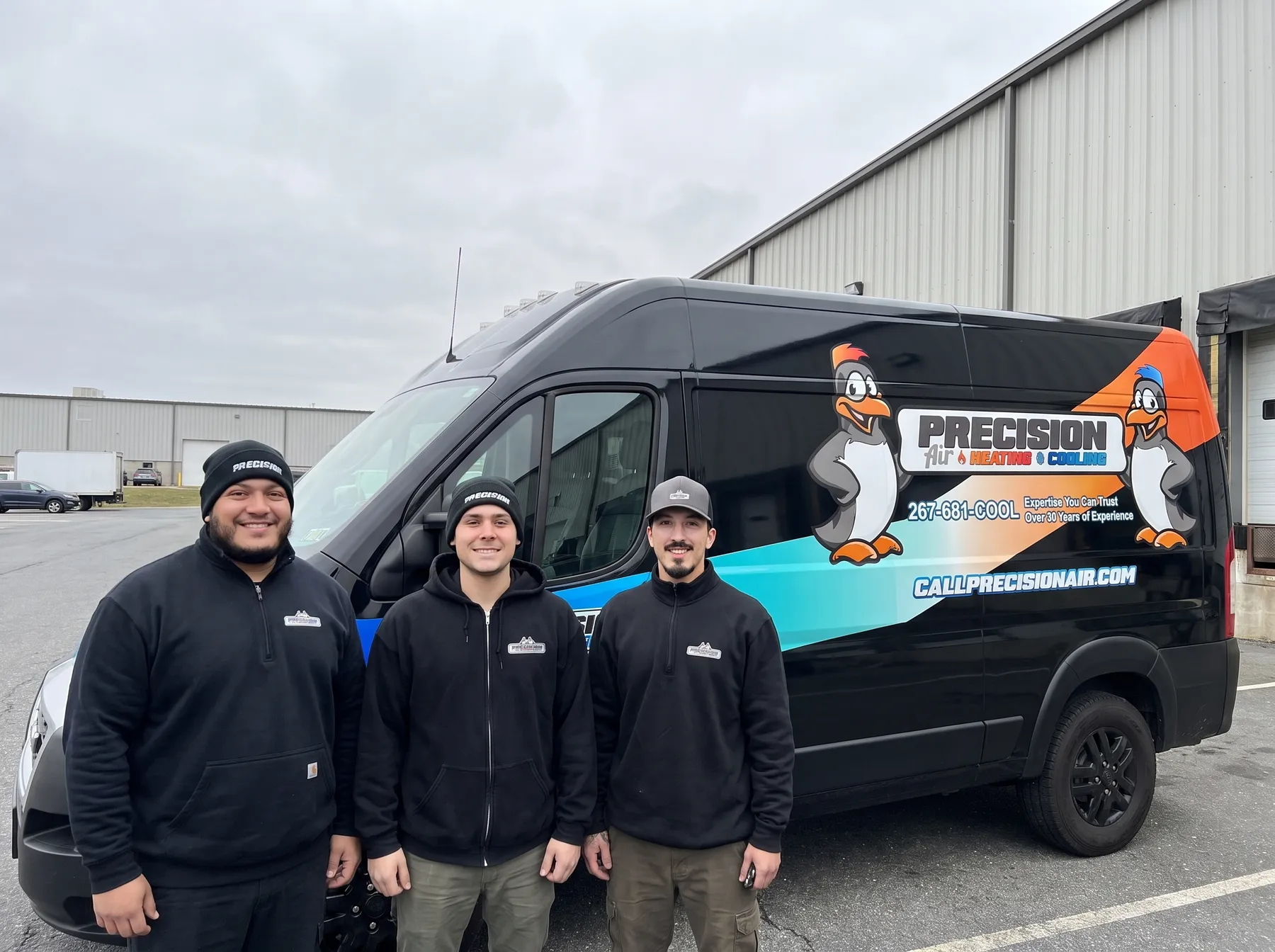 Three Precision Air technicians in front of a wrapped service van