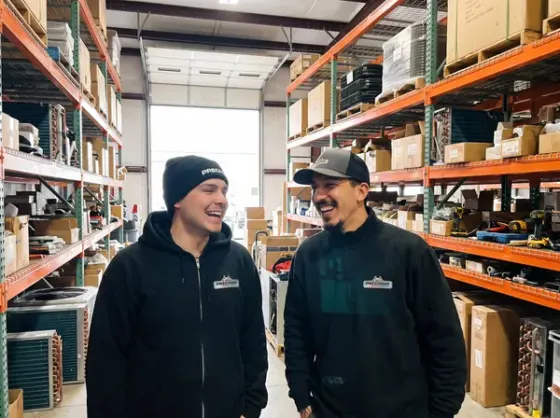 Two Precision Air technicians sharing a laugh in the parts warehouse