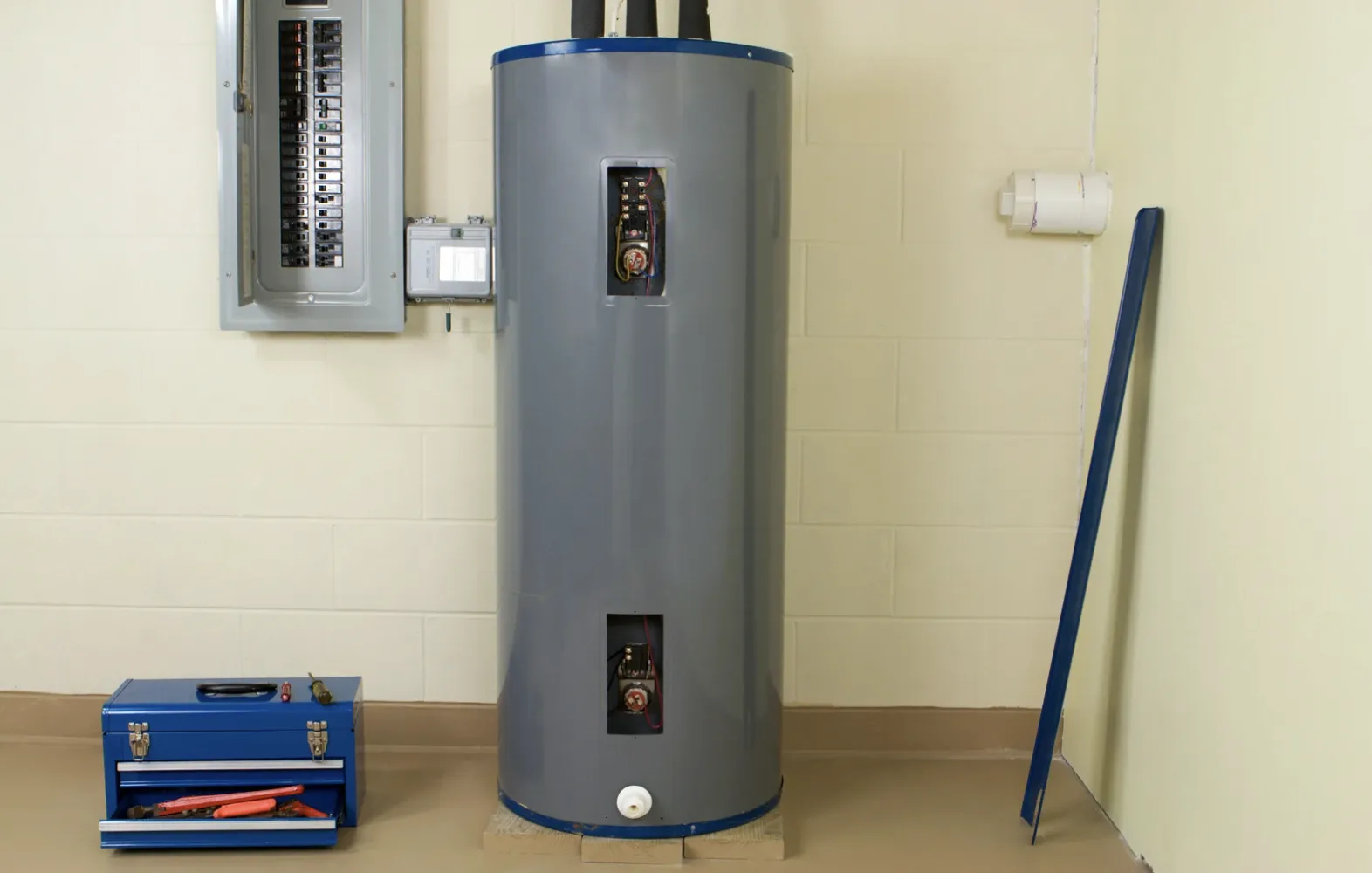Electric tank water heater with both element access panels open and a technician toolbox alongside, ready for a maintenance visit | Precision Air